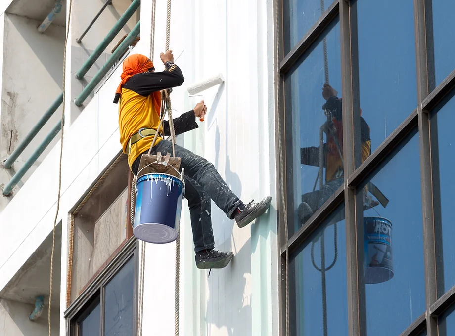 Worker painting building exterior